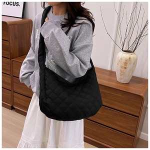 Vue détaillée du sac bandoulière noir matelassé avec motifs losanges et large bandoulière