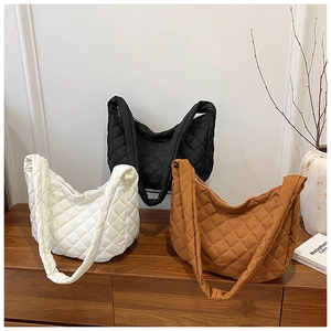 Détail des sacs cabas matelassés en coloris crème, noir et marron caramel