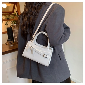 Chic white leather handbag for women featuring a stylish bow buckle on a city street