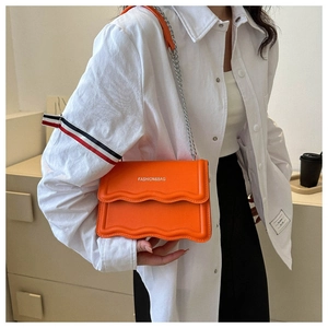 Detail der orangefarbenen Handtasche mit Wellenrand und FASHION & BAG Prägung