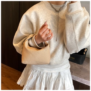 Detailed close-up of the woven texture and metal zipper on this stylish beige tote bag