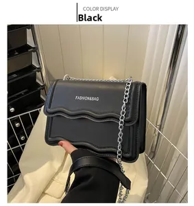 Detail einer schwarzen Wellenkanten-Handtasche mit Modelogo und Silberkette