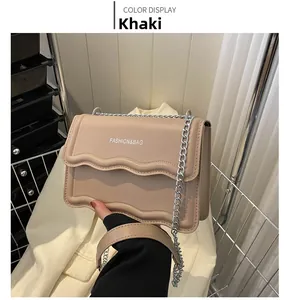 Detailansicht der khakifarbenen Tasche mit Wellenfalten und silberner Metallkette