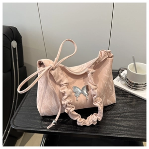 Dettaglio borsa a spalla plissettata rosa chiaro con farfalla d'argento e volant