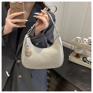 Detailansicht der silbergrauen Hobo-Bag mit Krokoprägung und goldenem M-Metallanhänger