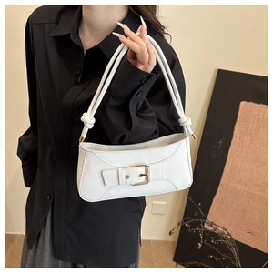 Detail of white leather underarm bag featuring a gold buckle and knotted shoulder strap