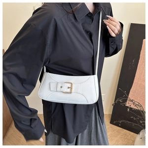 Detail of white leather underarm bag featuring a gold metal buckle and adjustable strap