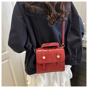 Sac à dos rétro en similicuir rouge foncé porté par un mannequin en intérieur chic