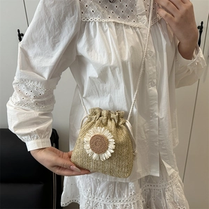 Straw drawstring bucket bag with sunflower accent and woven crossbody strap