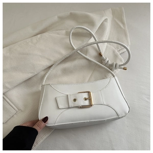 Close-up of white minimalist square bag featuring a vintage golden buckle and slim strap