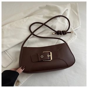Close-up of matte dark brown baguette bag with golden square buckle on knit background
