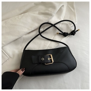 Detail of black underarm bag with smooth finish and large gold buckle closure