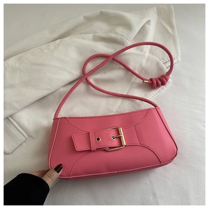 Detail of pink baguette bag with large gold square buckle and stylish knotted shoulder strap