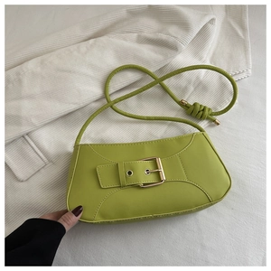 Detail of avocado green PU leather bag featuring a large gold buckle and knotted strap