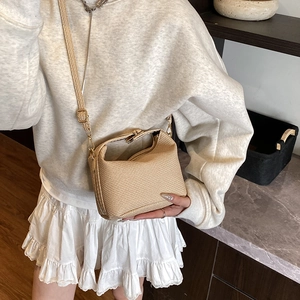 Elegant beige woven crossbody bag with metal frame clasp and adjustable strap