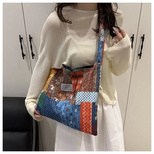 Detail of colorful floral canvas tote bag showing the textured fabric and shoulder strap