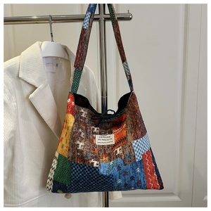Detail of vintage patchwork tote bag with colorful floral patterns and drawstring closure