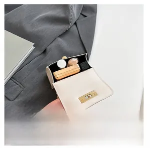 Internal view of cream mini square bag showing space for lipstick and makeup items
