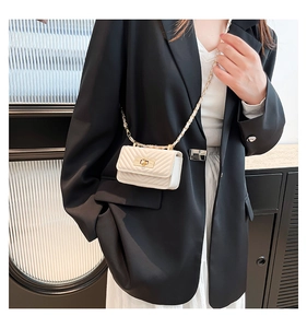 Detail of a creamy mini crossbody bag with V-quilted texture and gold chain strap