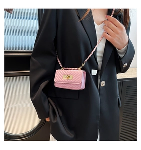 Detail of pink quilted mini crossbody bag with golden twist lock and chain strap