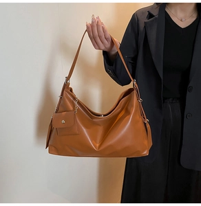 Detail der karamellbraunen Ledertasche mit passendem kleinen Etui an der Kette