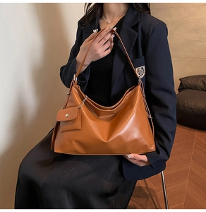 Brown soft leather oversized tote bag with matching mini chain pouch on model