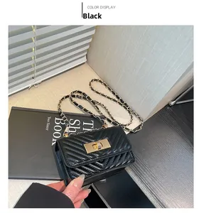 Detail of black V-quilted mini square bag featuring gold metal turn-lock and chain strap