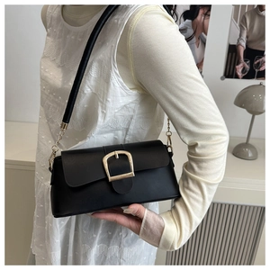 Close-up of black leather underarm bag with signature gold horseshoe buckle and chain strap