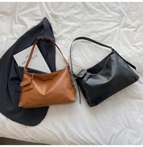 Detail of caramel and black soft leather tote bags with adjustable buckle straps