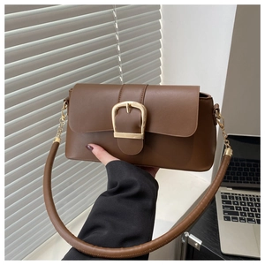 Detail view of coffee brown faux leather bag with large golden horseshoe metal buckle