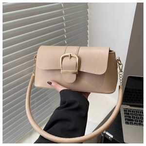 Detailed view of beige faux leather bag with oversized gold buckle and round handle