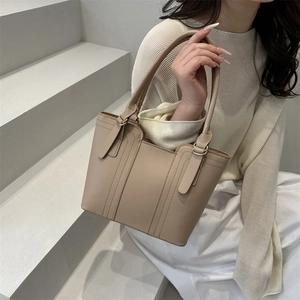 Minimalist beige leather bucket tote bag with gold metal rings for women daily wear