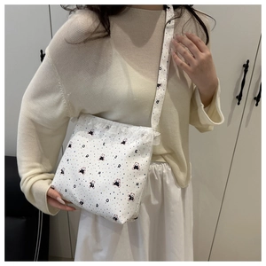 Détail du sac cabas blanc avec motifs ours, pois colorés et bordure en dentelle fine