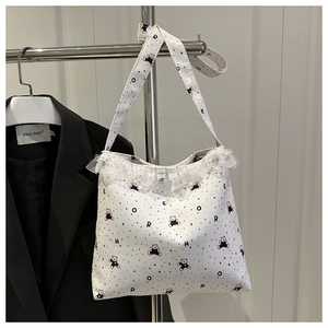 Détails de dentelle blanche et motifs d'ours sur un grand sac cabas en toile souple