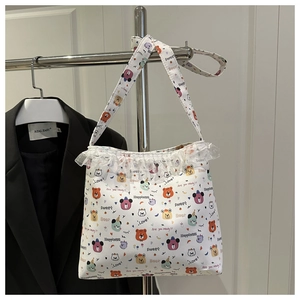 Gros plan du sac cabas en toile blanche avec imprimé ours et bordure en dentelle