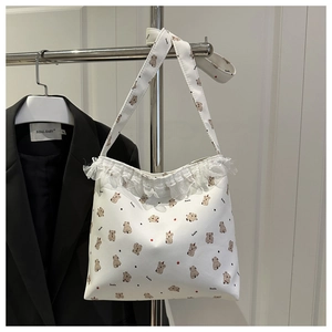 Détail du sac cabas en toile blanche avec motifs koala mignons et bordure en dentelle
