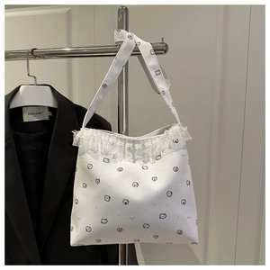 Détail du sac cabas blanc avec des imprimés d'animaux mignons et des bords en dentelle élégants