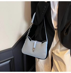 Detail showing light blue leather and grey woven fabric texture with silver chain