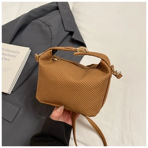 Gros plan du sac à main marron à texture tressée et boucle en métal doré élégante