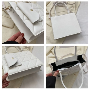 Detail view of white quilted tote bag with detachable pouch and golden metal hardware