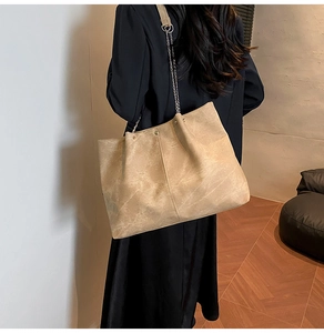 Detail of soft matte faux leather tote with metallic chain strap in camel brown finish