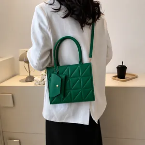 Close-up of vibrant green quilted handbag with matching coin purse and gold hardware detail