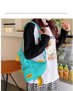 Detail of creative duck canvas crossbody bag featuring yellow beak and adjustable strap