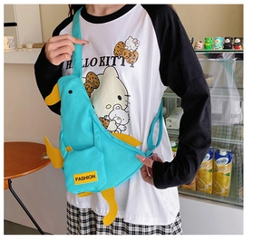 Detail of cute duck-shaped canvas crossbody bag with adjustable strap and front pocket