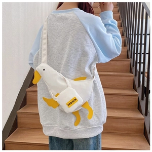 Detail shot of the 3D white duck canvas chest bag with yellow beak and fashion label