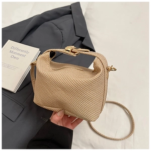 Détail d'un sac à main rétro tissé avec fermoir rotatif doré et texture raffinée