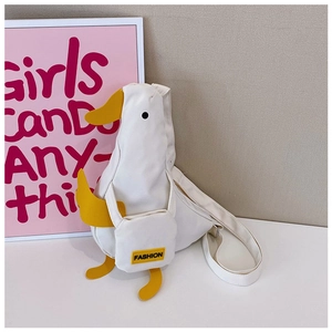 Detail view of a white canvas duck-shaped crossbody bag with yellow beak and fashion tag