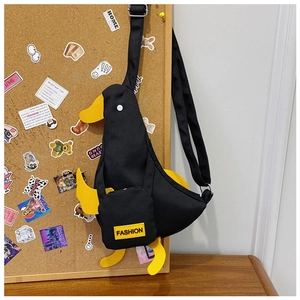 Detail of cute duck-shaped canvas crossbody bag with yellow beak and FASHION tag