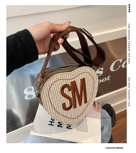 Détail du sac à bandoulière en cœur avec texture tissée et grand logo SM accentué