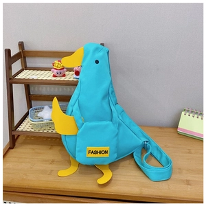 Detail of the duck-shaped crossbody bag featuring a blue fabric and yellow duckling elements